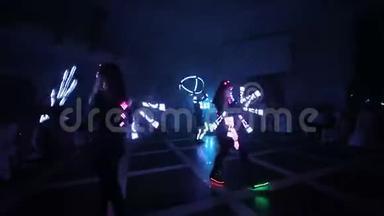 激光LED显示。 艺术家在黑暗的房间里展示舞蹈和激光表演。 衣服散发着冰和激光的光芒。 夜晚